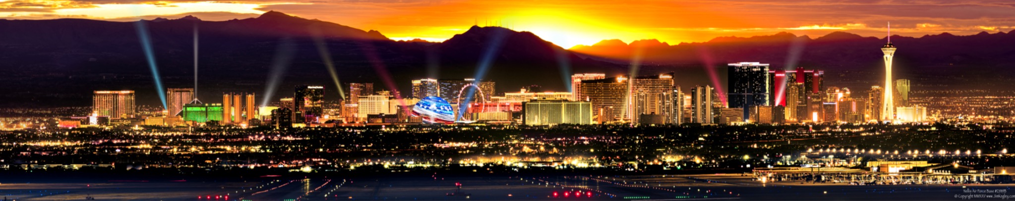 Las Vegas skyline under an orange sunset and mountain silhouettes.